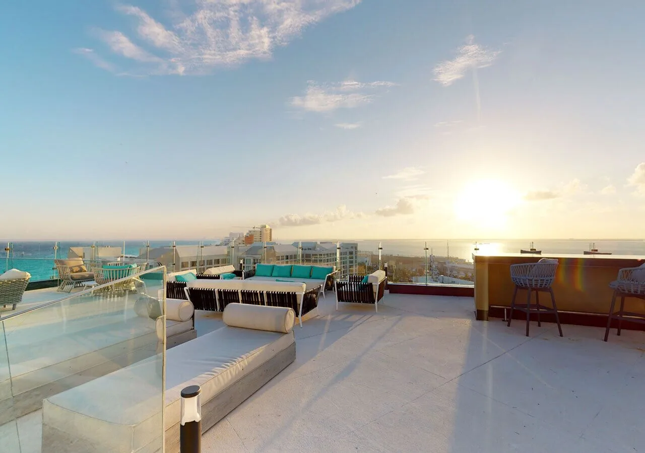 Rooftop lounge seating and bar area at sunset at Park Royal Beach Cancun.
