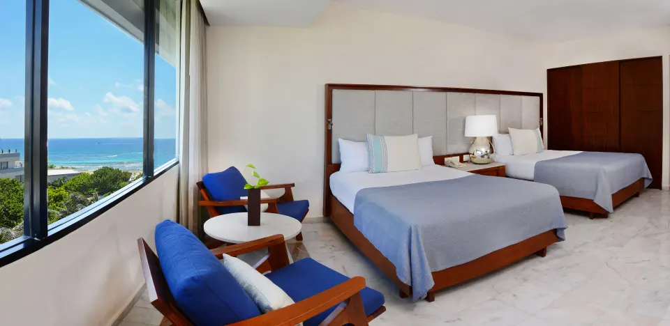 Deluxe ocean view room with two beds and window seating at Park Royal Beach Cancun.