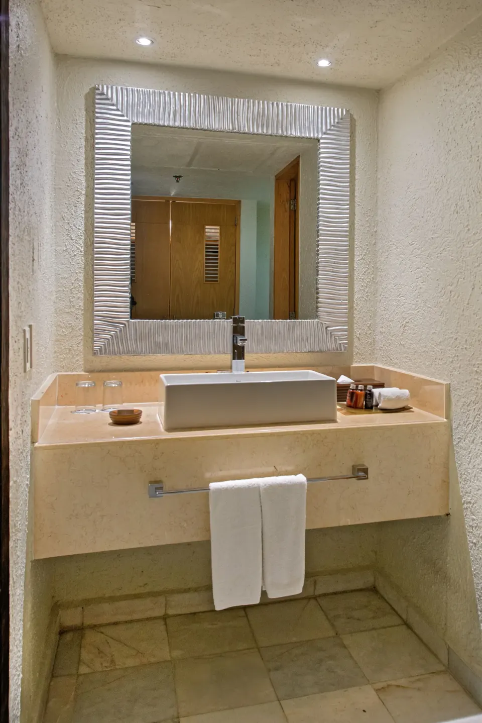 Deluxe room bathroom vanity with mirror and towels at Park Royal Beach Cancun.