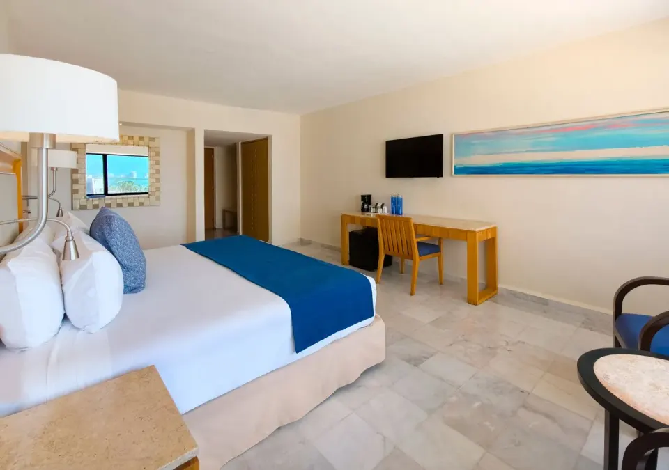 Deluxe king room with ocean artwork, desk and seating at Park Royal Beach Cancun.