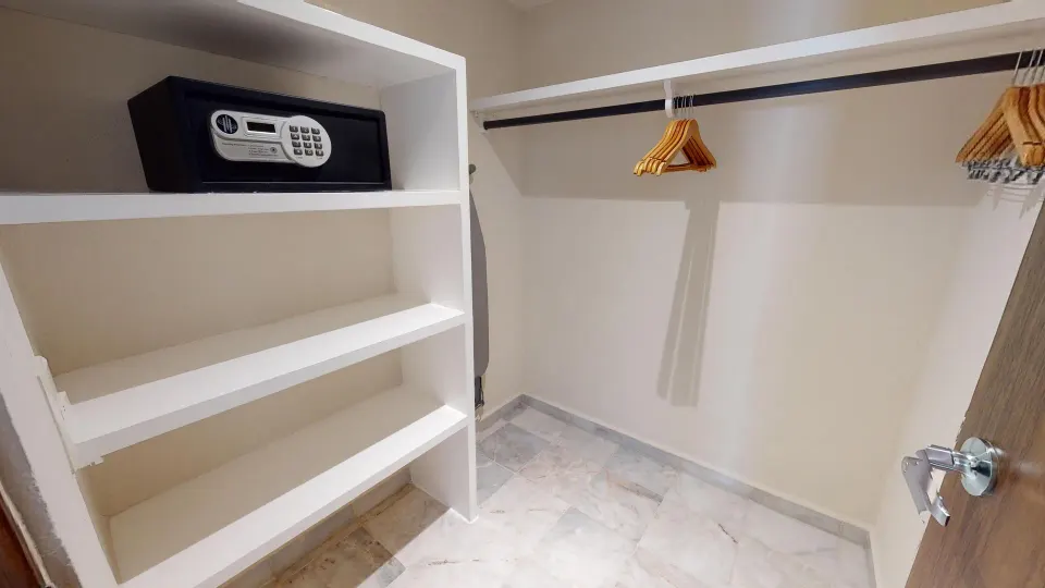 Family Suite closet with shelves, hanging rods, wooden hangers, and safe at Park Royal Beach Cancun.