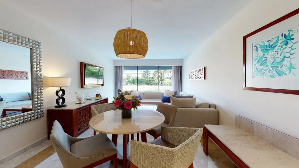 Family Suite dining area with round table, pendant light, and lounge seating at Park Royal Beach Cancun.