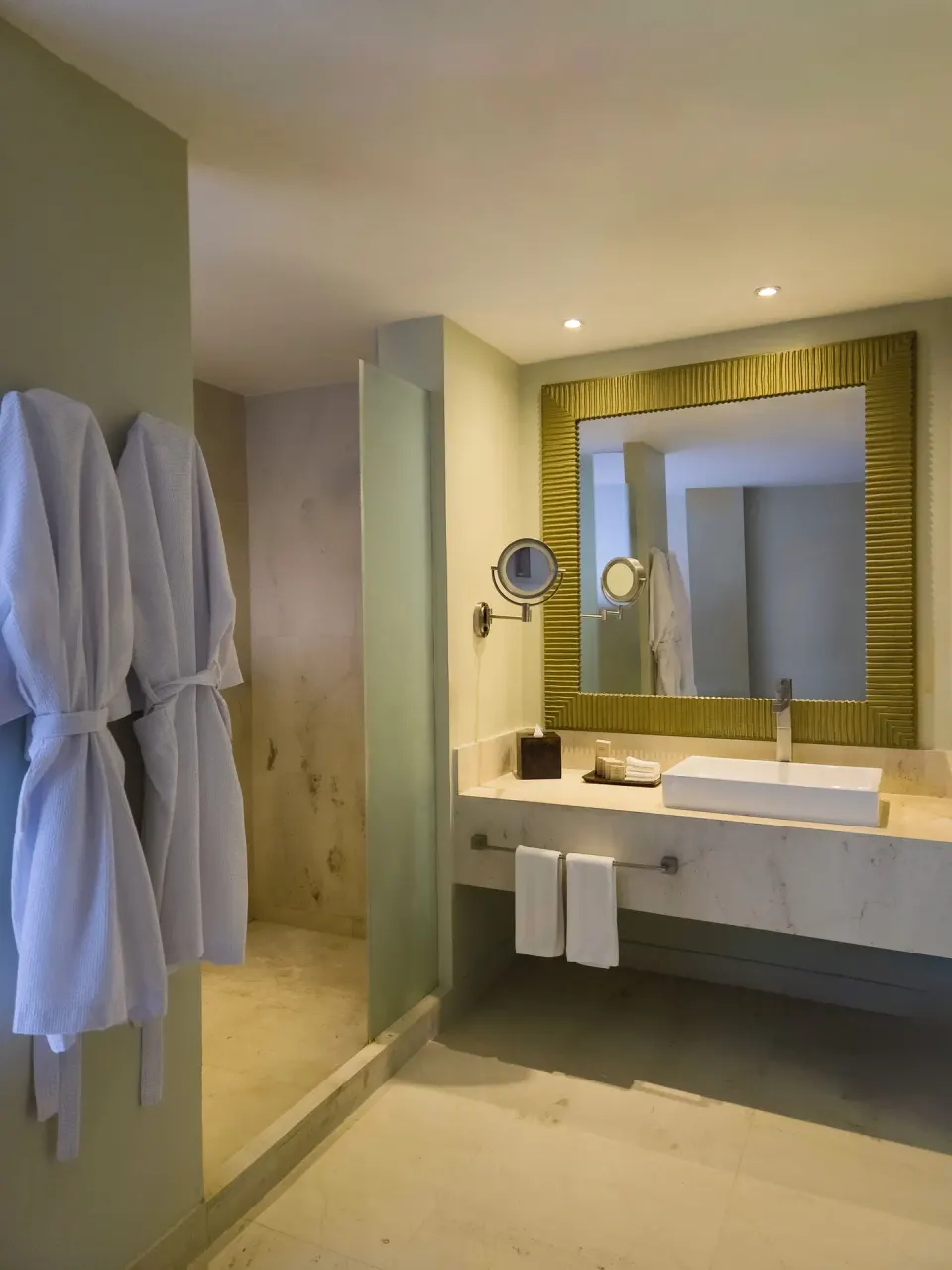 Honeymoon Room bathroom with robes and vanity at Park Royal Beach Cancun.