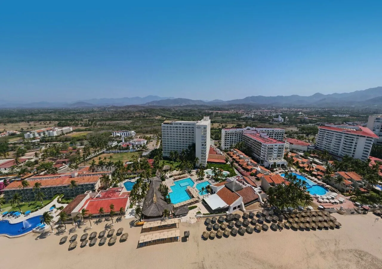 Aerial view of pools, beach palapas, and resort buildings at Park Royal Beach Ixtapa.
