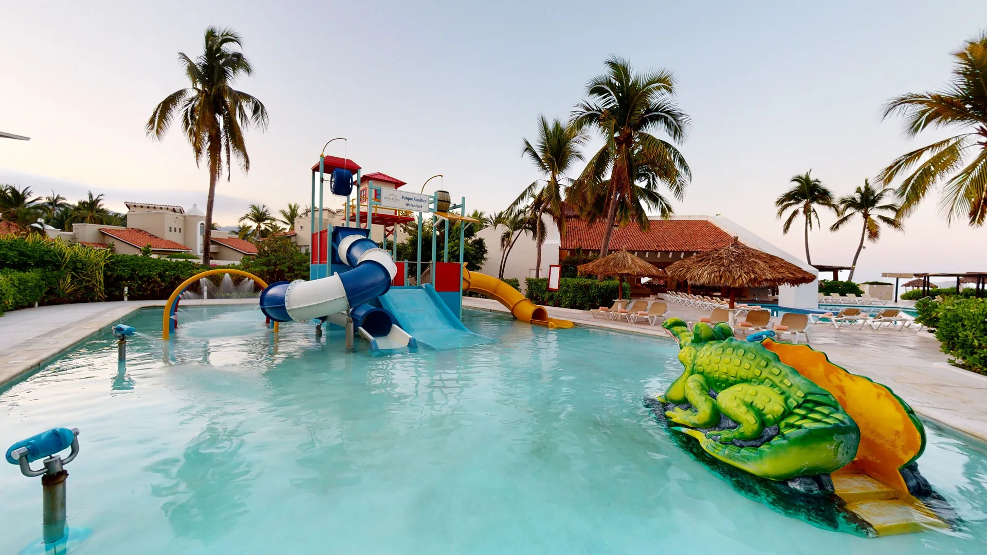 Children's pool with slides and palm trees at Park Royal Beach Ixtapa.