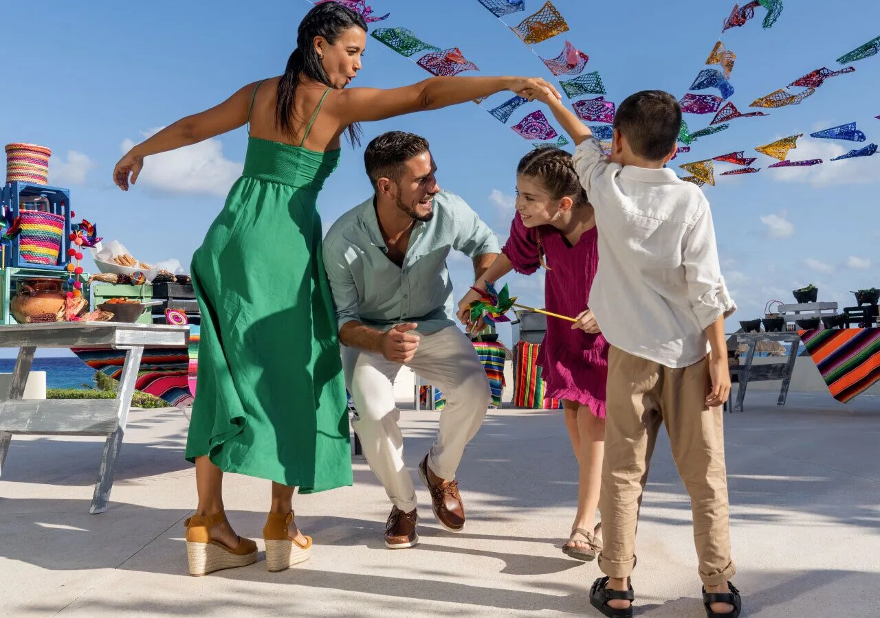 Family dancing beneath colorful decorations at Park Royal Beach Ixtapa.