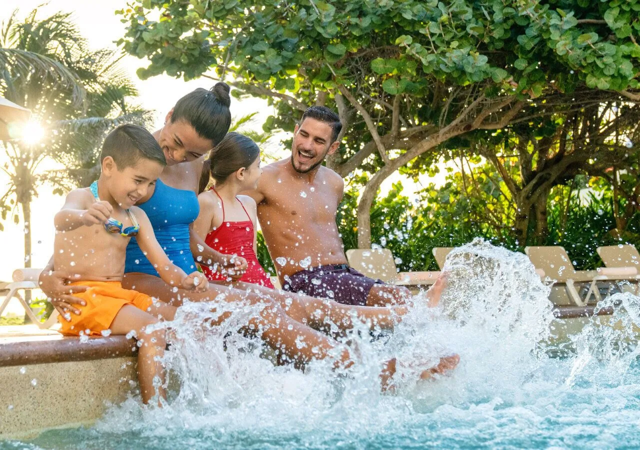 Family splashing at the pool edge at Park Royal Beach Ixtapa.