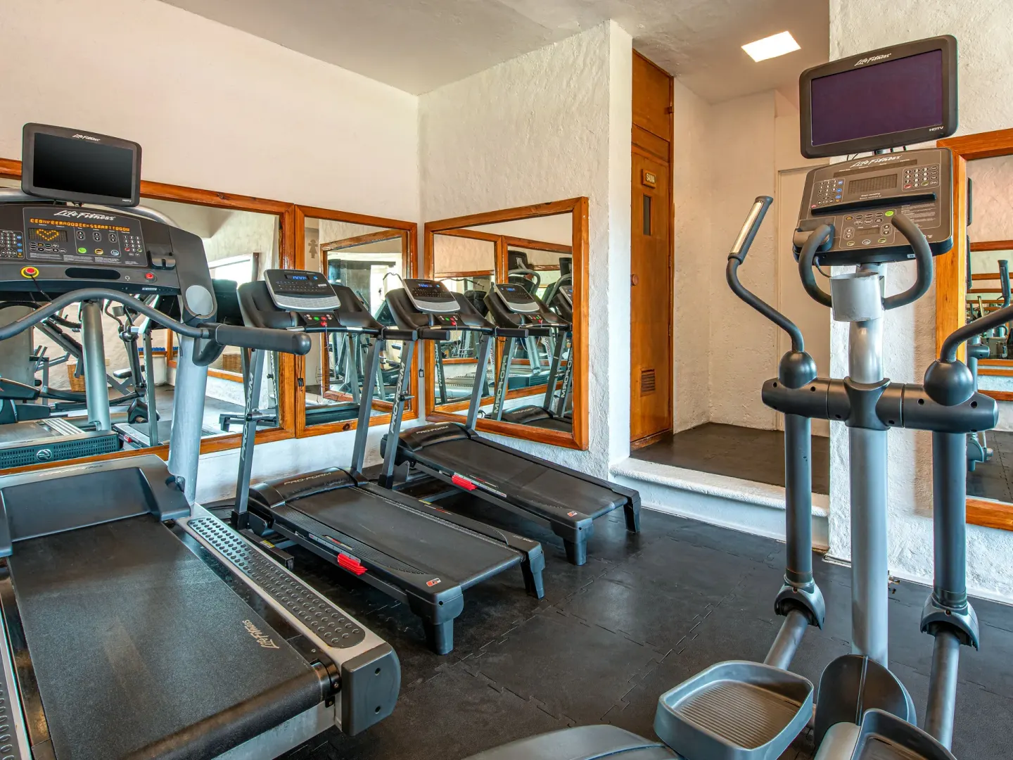 Fitness room with treadmills, elliptical machine, and mirrors at Park Royal Beach Ixtapa.