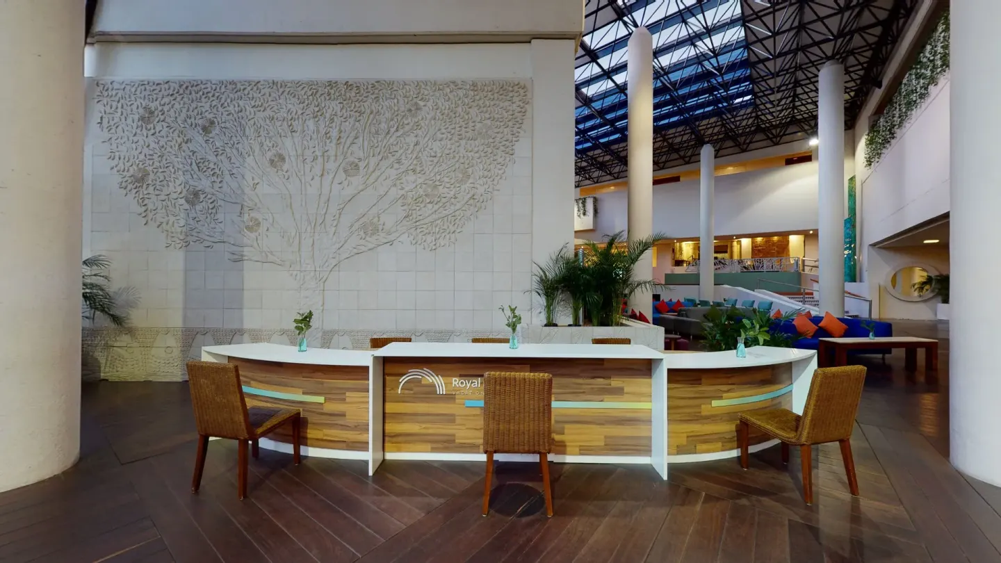 Lobby reception desks beneath a tall atrium at Park Royal Beach Ixtapa.