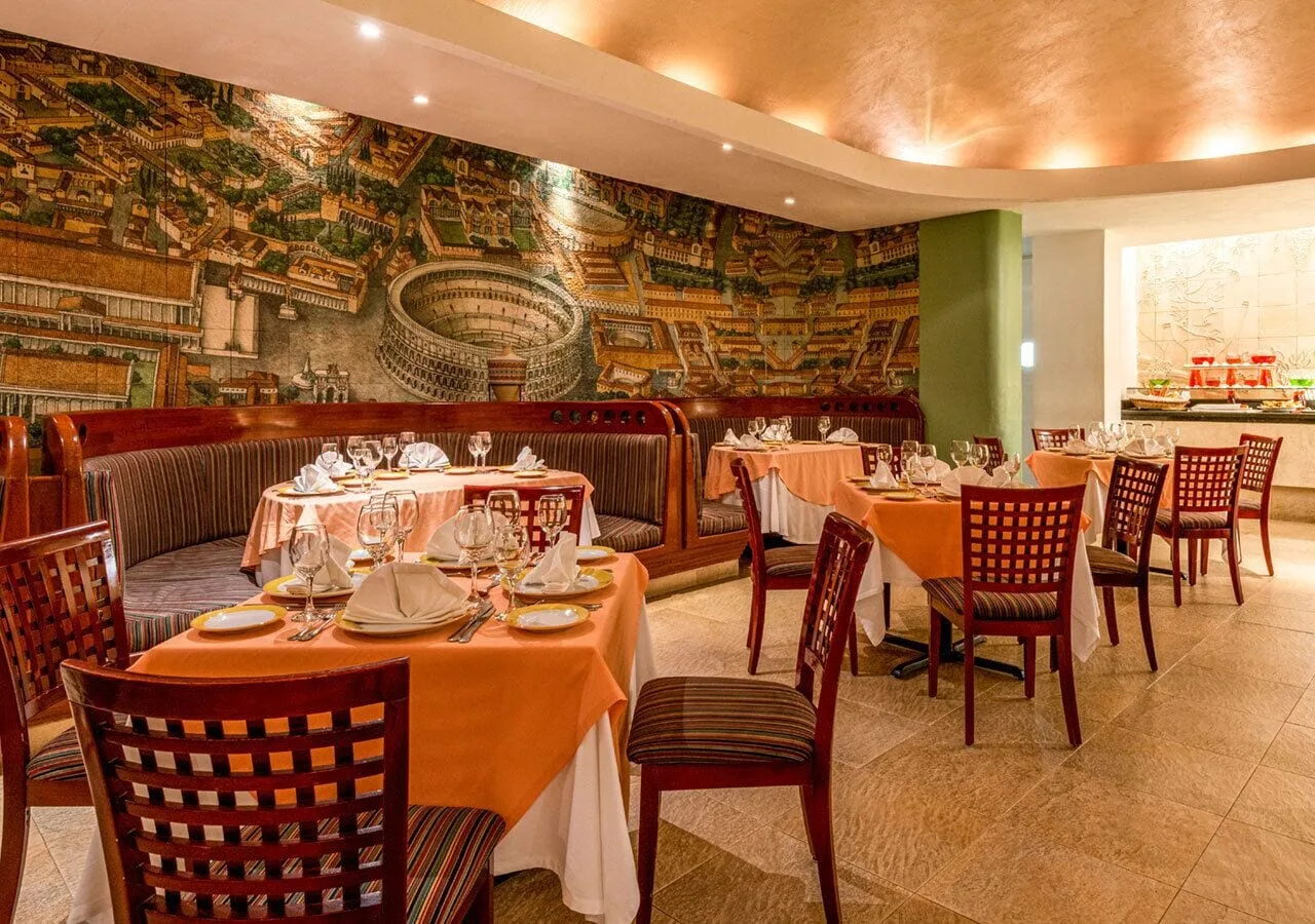 Italian-style dining room with mural and set tables at Park Royal Beach Ixtapa.