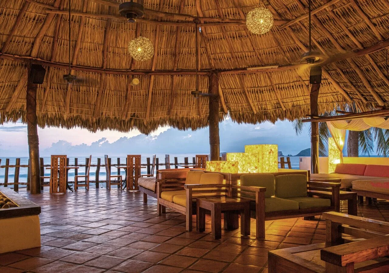 Thatched oceanfront lounge seating at Park Royal Beach Ixtapa.