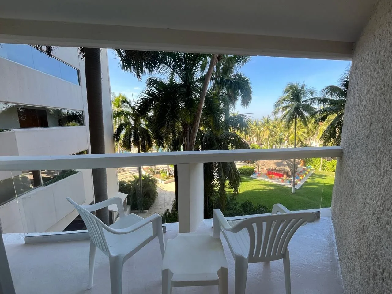 Deluxe Nature View balcony with chairs and palm garden at Park Royal Beach Ixtapa.