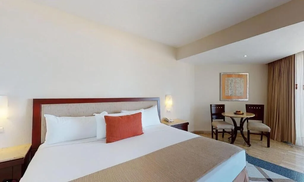Deluxe Nature View room with king bed and dining table at Park Royal Beach Ixtapa.