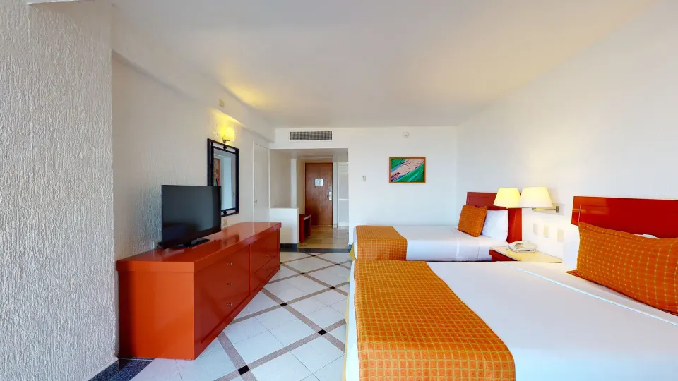 Deluxe Nature View room with two beds and TV console at Park Royal Beach Ixtapa.