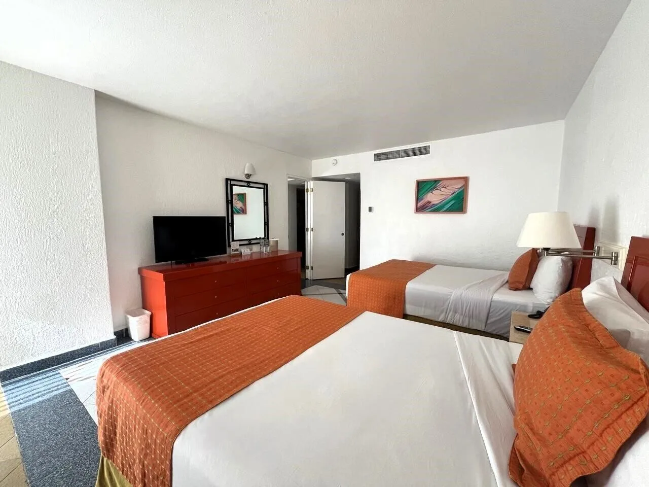 Family Suite bedroom with two beds and dresser at Park Royal Beach Ixtapa.