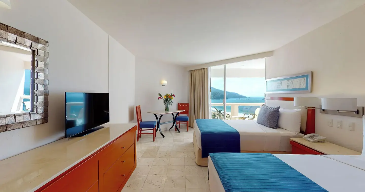 Master Suite bedroom with two beds, TV, dresser, and ocean view at Park Royal Beach Ixtapa.