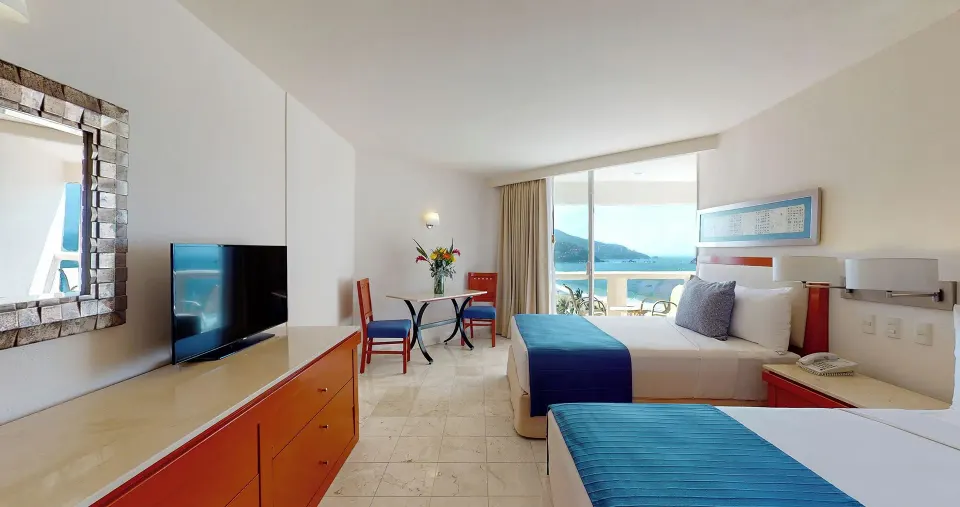 Master Suite bedroom with two beds, TV, dresser, and ocean view at Park Royal Beach Ixtapa.
