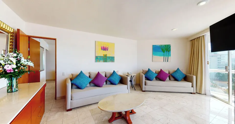 Master Suite sitting room with two sofas and balcony doors at Park Royal Beach Ixtapa.