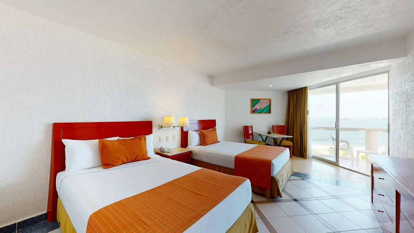 Premier Ocean View room with two beds and balcony doors at Park Royal Beach Ixtapa.