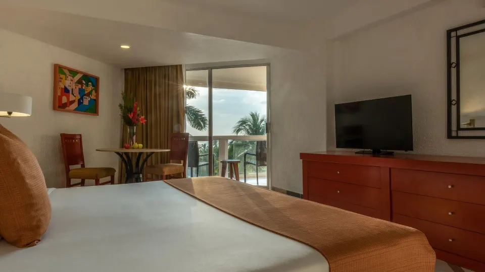 Premier Room Ocean View with bed, TV, and balcony seating at Park Royal Beach Ixtapa.
