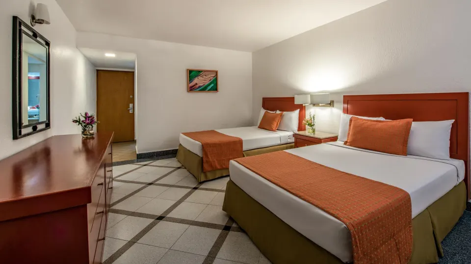 Premier Room Ocean View with two beds, dresser, and entry door at Park Royal Beach Ixtapa.