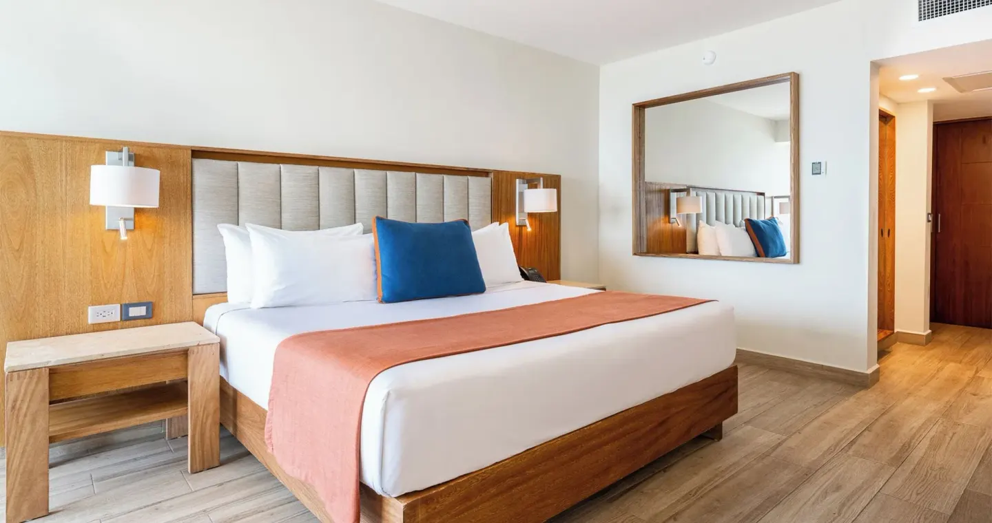 Royal Ocean Front king bed with wood headboard at Park Royal Beach Ixtapa.