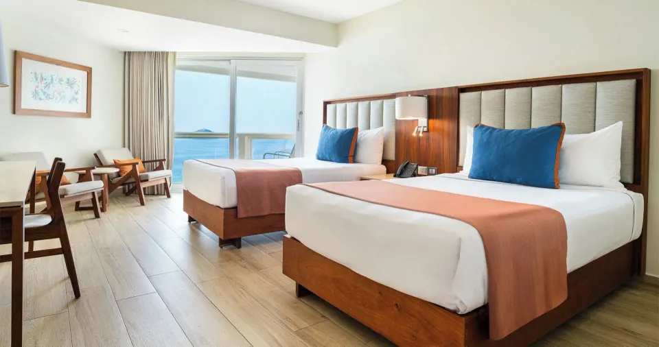 Royal Ocean View guest room with two beds and balcony at Park Royal Beach Ixtapa.