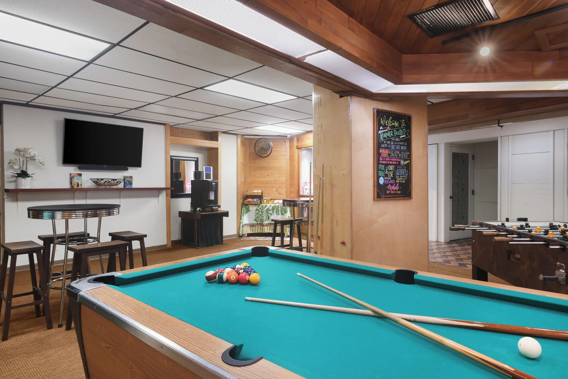 Game room with pool table, foosball table, seating, and TV at Park Shore Waikiki.