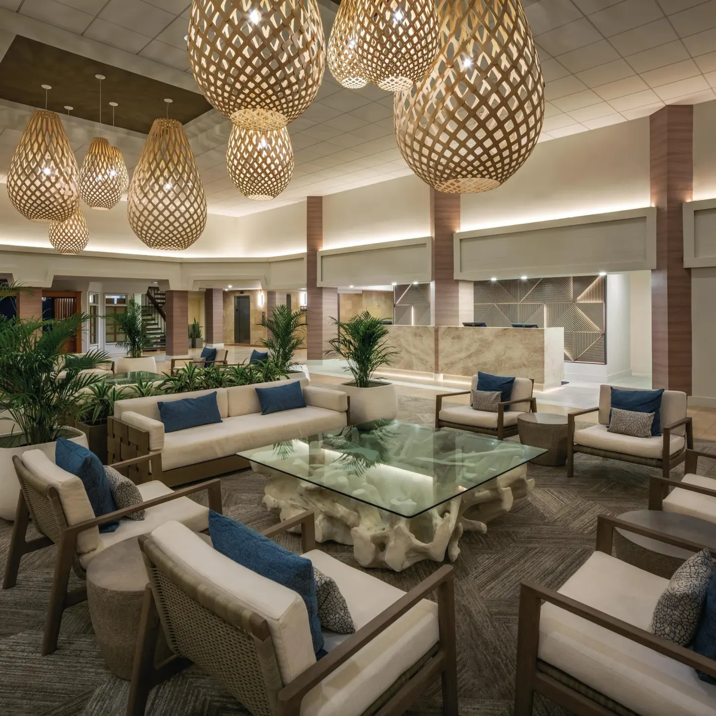Lobby lounge with glass table and woven lights at Park Shore Waikiki.