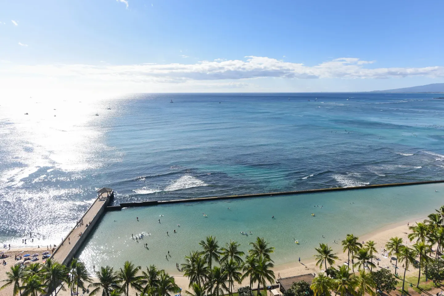 Wide ocean view over Waikiki Beach, palm trees, and the seawall at Park Shore Waikiki.