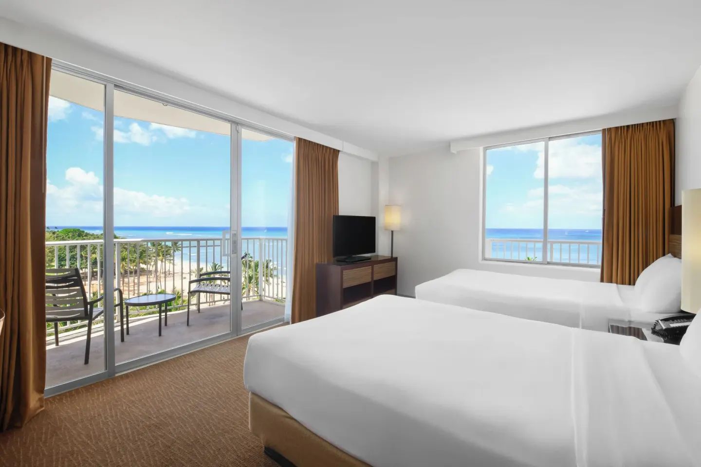 Guest room with two beds, balcony, and ocean view at Park Shore Waikiki.
