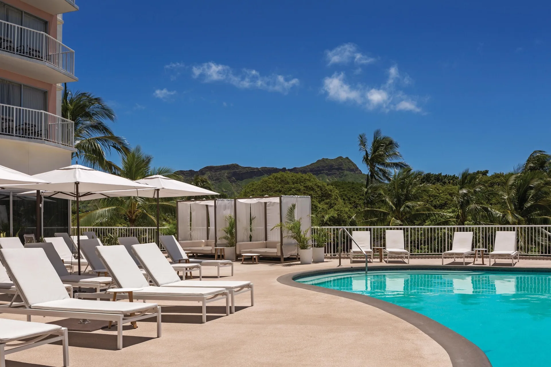 Pool deck with loungers, umbrellas, and Diamond Head views at Park Shore Waikiki.