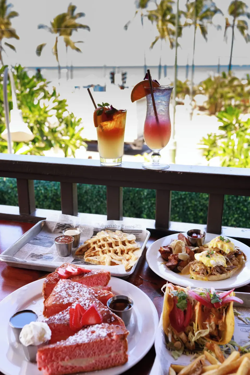 Brunch plates and tropical drinks overlook Waikiki Beach at Park Shore Waikiki.
