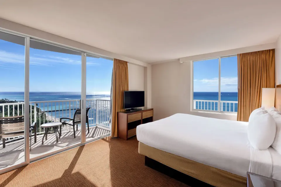 Oceanfront corner guest room with king bed and balcony at Park Shore Waikiki.