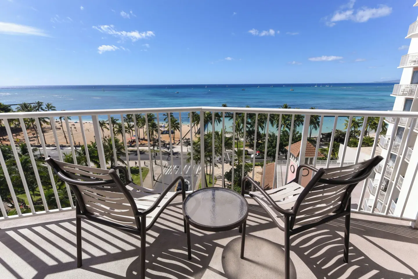 Ocean View room balcony with chairs facing Waikiki Beach at Park Shore Waikiki.