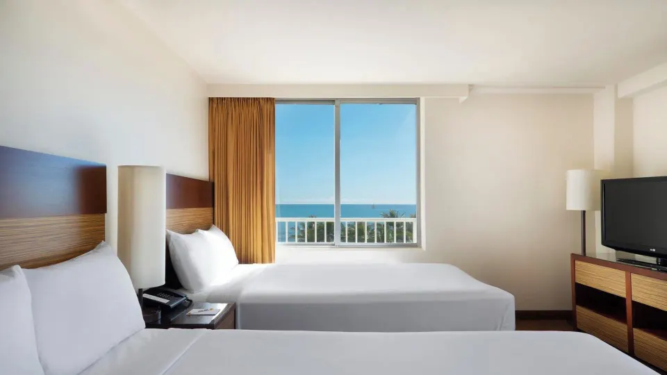 Two-bed Ocean View room with TV and window at Park Shore Waikiki.
