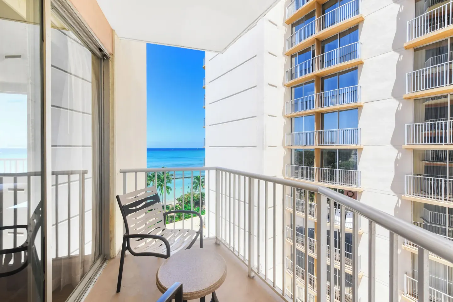 Partial ocean view balcony with chair and table at Park Shore Waikiki.