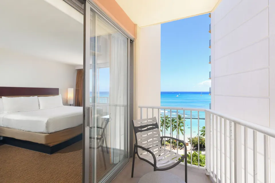 King bed room viewed from balcony with ocean beyond at Park Shore Waikiki.