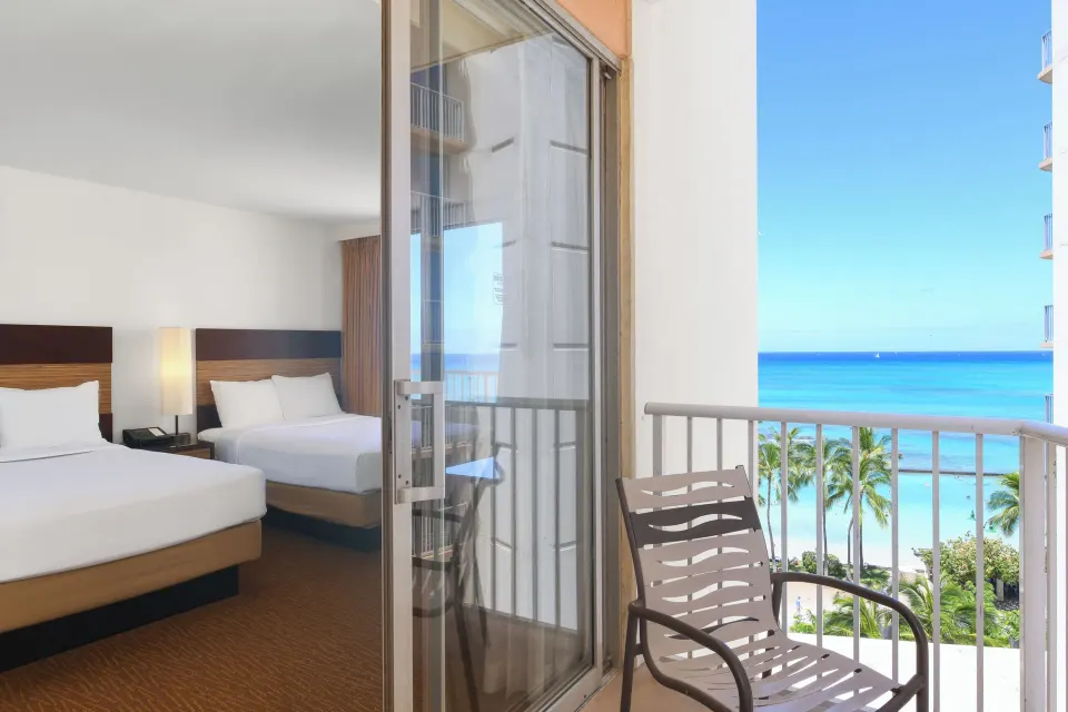 Two-bed room seen from balcony with partial ocean view at Park Shore Waikiki.