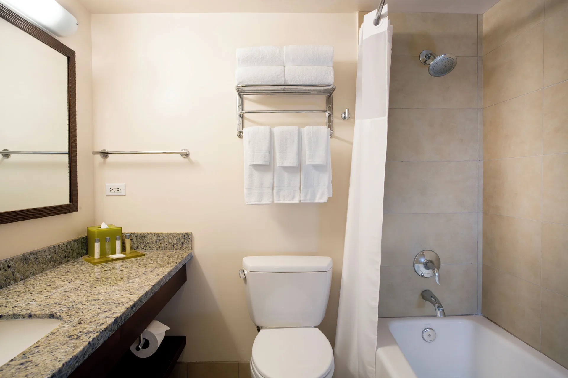 Standard Room bathroom with granite vanity, toilet, towels, and tub shower at Park Shore Waikiki.