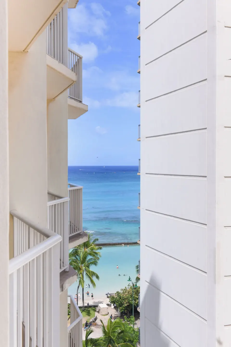 Ocean and beach view between hotel balconies from a Standard Room at Park Shore Waikiki.