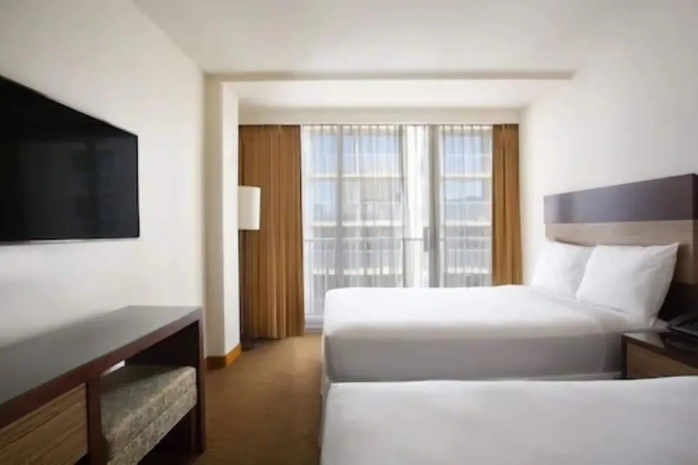 Standard Room with two beds, wall-mounted TV, desk, and balcony doors at Park Shore Waikiki.