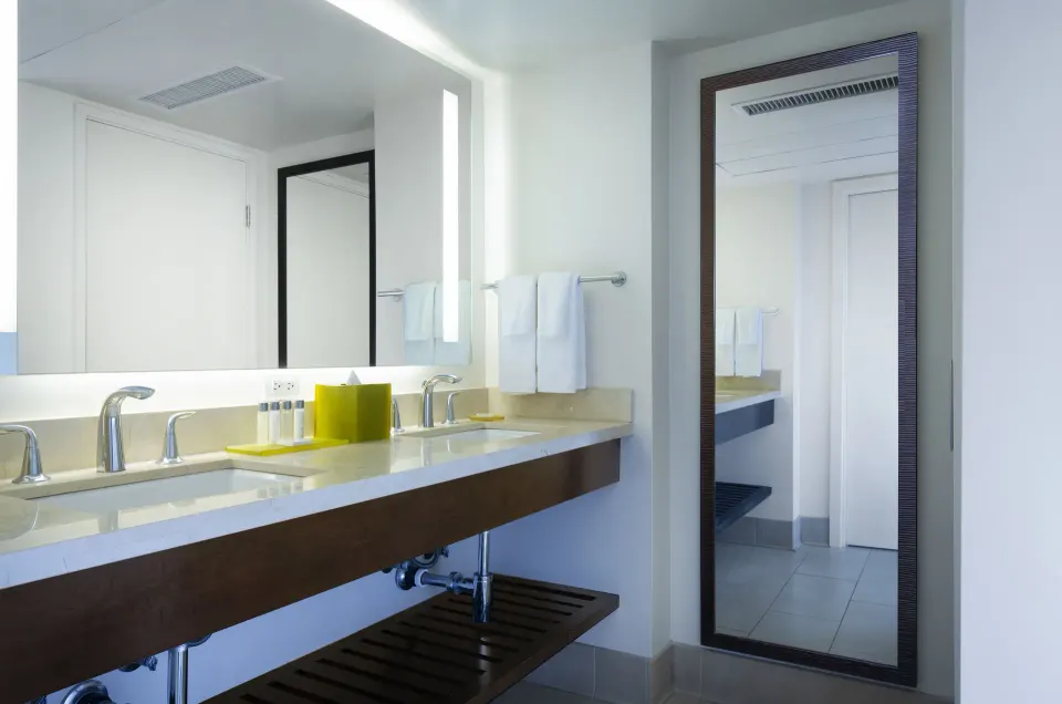 Suite bathroom vanity with double sinks and tall mirror at Park Shore Waikiki.