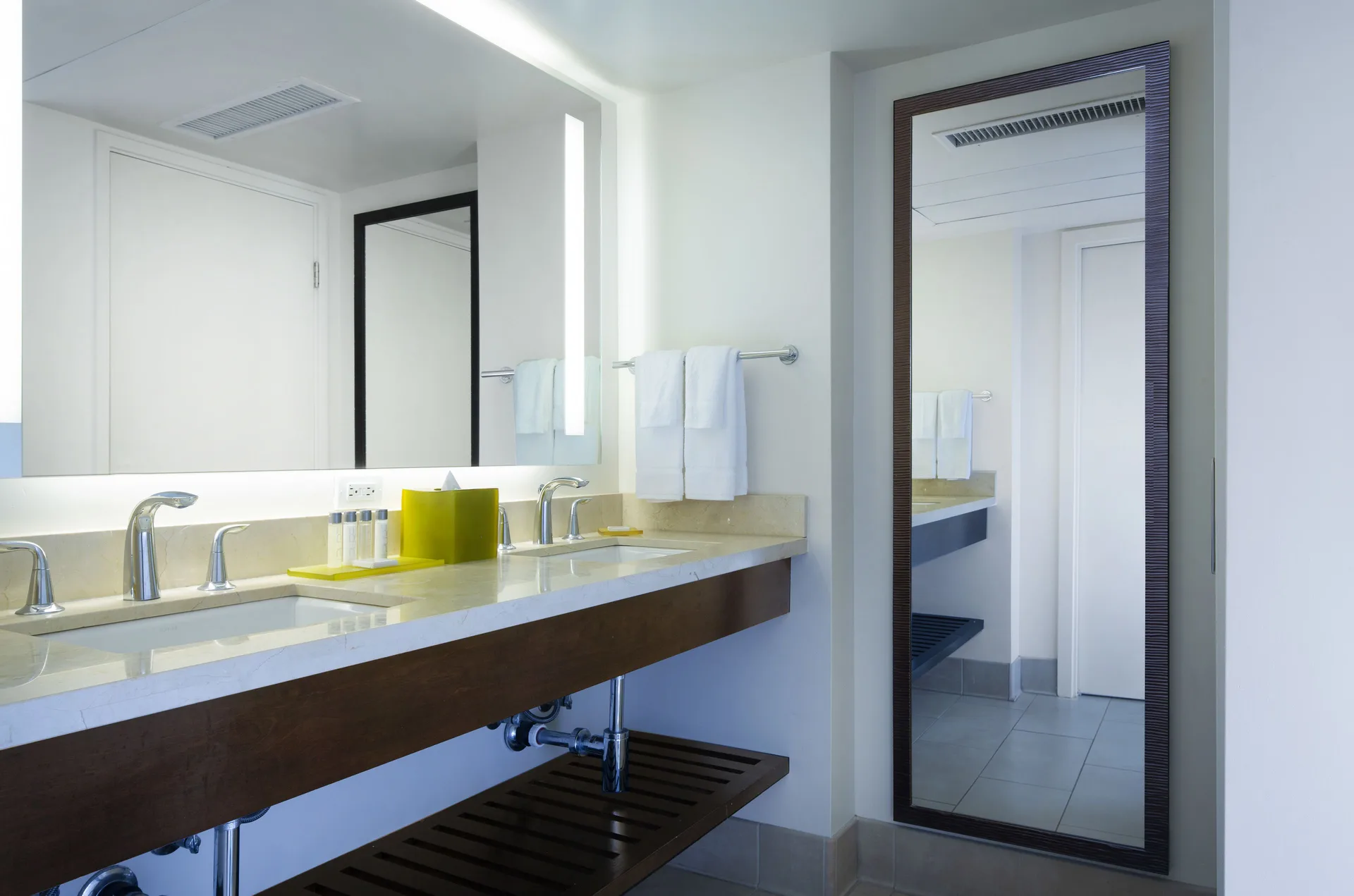 Suite bathroom vanity with double sinks and tall mirror at Park Shore Waikiki.