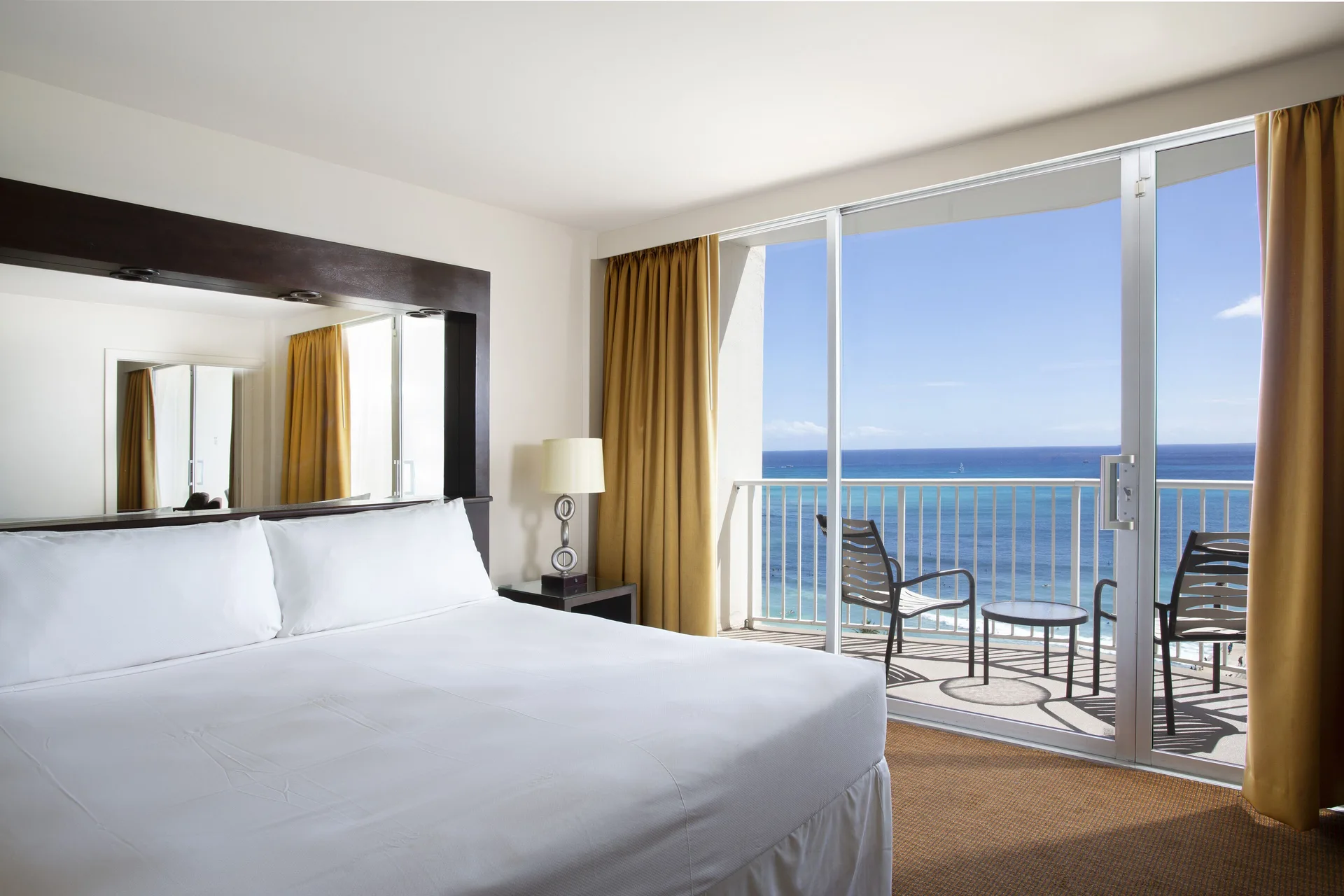 Oceanfront one-bedroom suite king bed and balcony at Park Shore Waikiki.