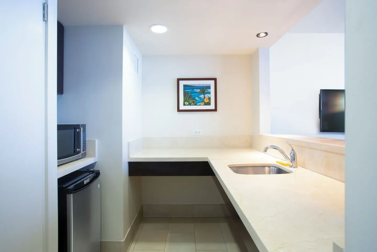 Suite kitchenette with sink, counter, microwave, and mini fridge at Park Shore Waikiki.