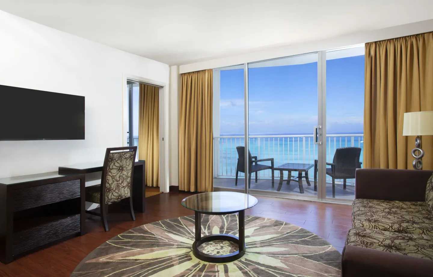Oceanfront suite living room with balcony seating at Park Shore Waikiki.