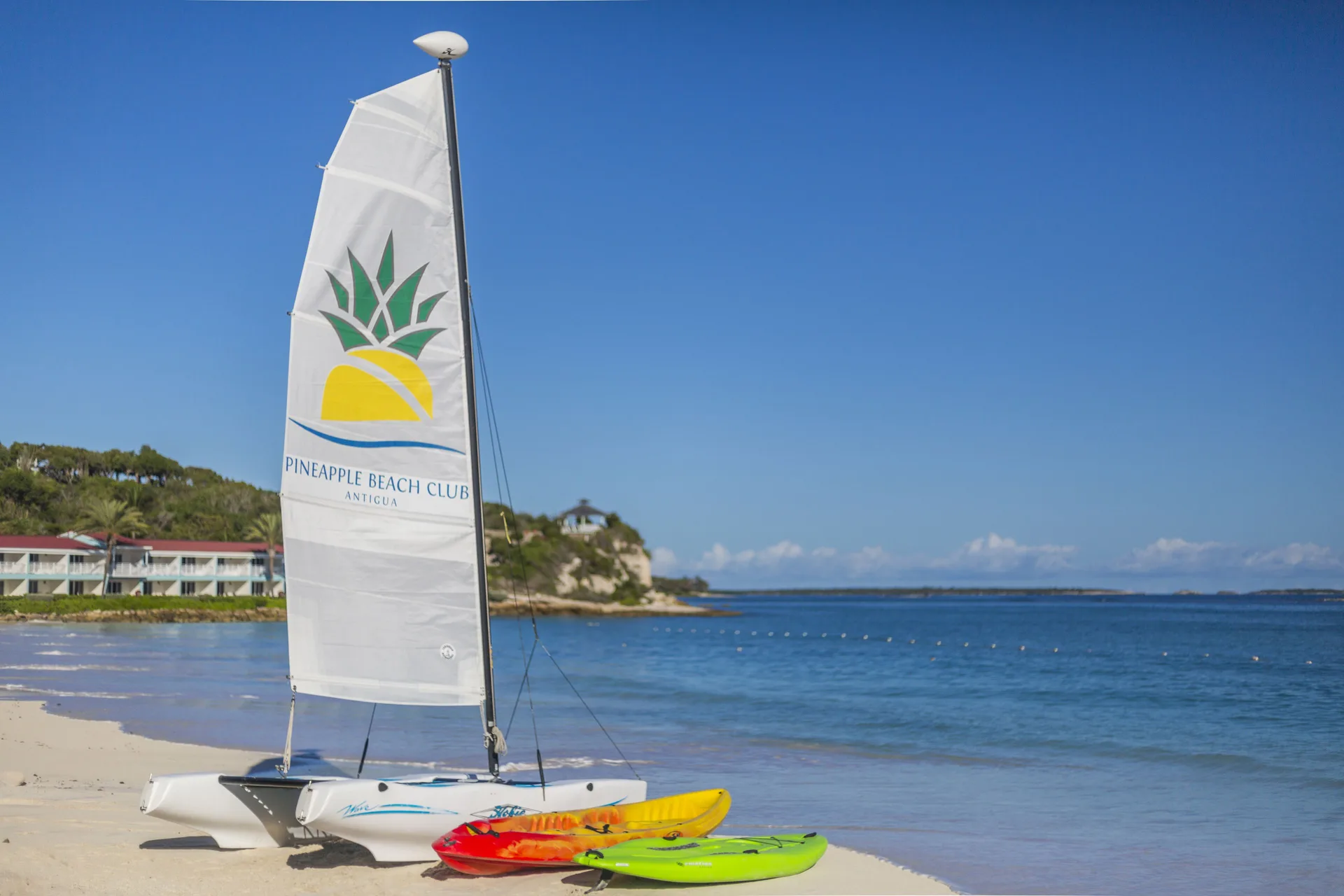 Catamaran sail and kayaks on the beach at Pineapple Beach Club Antigua.