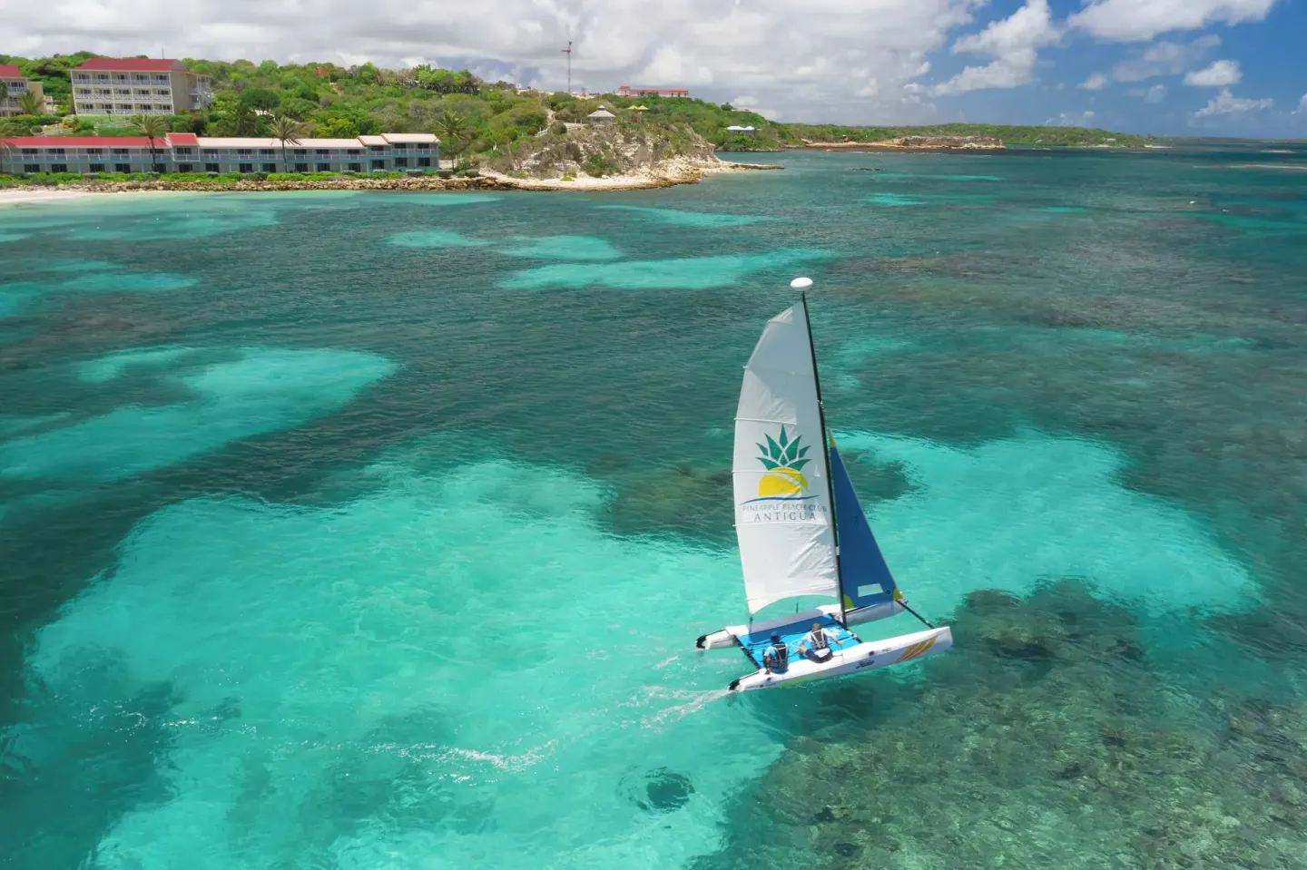 A sailboat glides over turquoise water near Pineapple Beach Club Antigua.