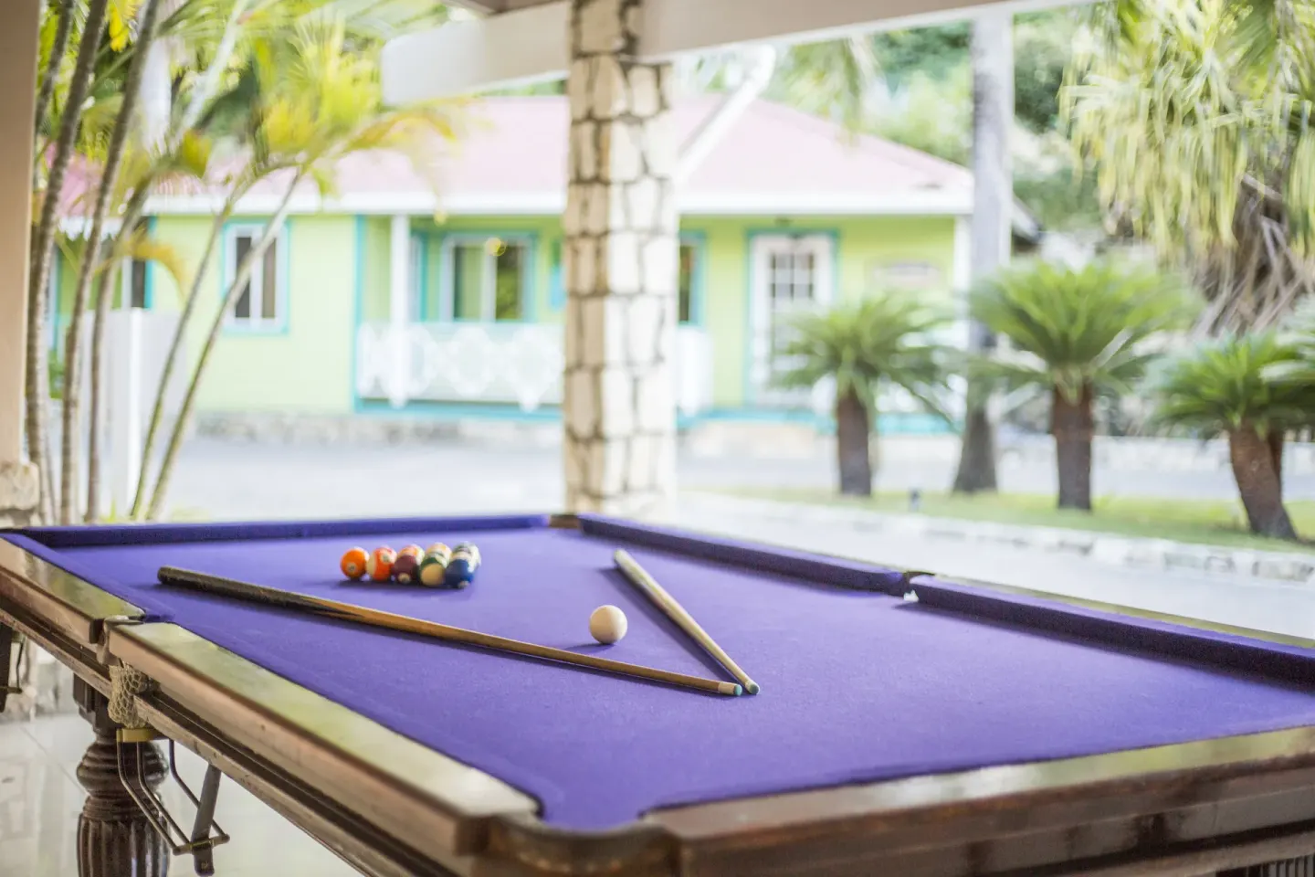 A purple-felt pool table sits in a covered game area at Pineapple Beach Club Antigua.